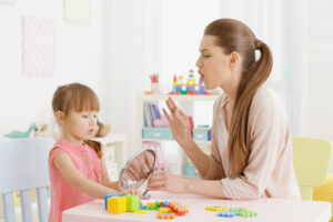 Cute little girl with ASD at speech therapist office