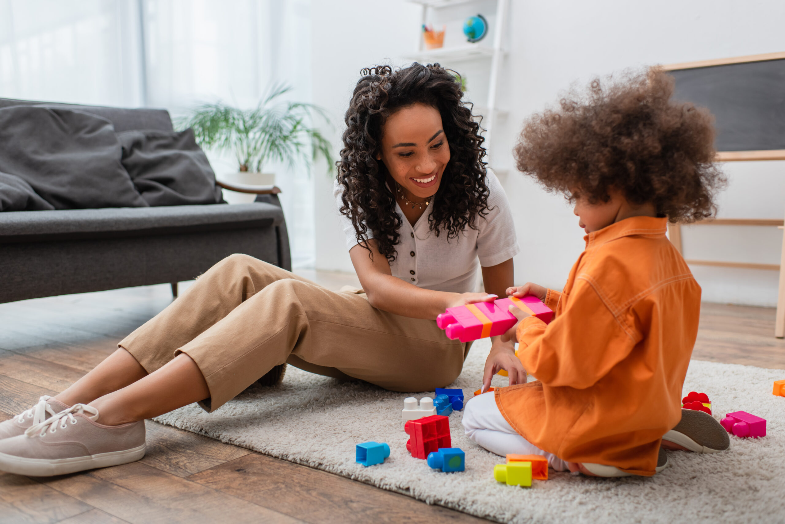 What is a Board Certified Behavior Analyst? BCBA playing with blocks on the floor with an Autistic child