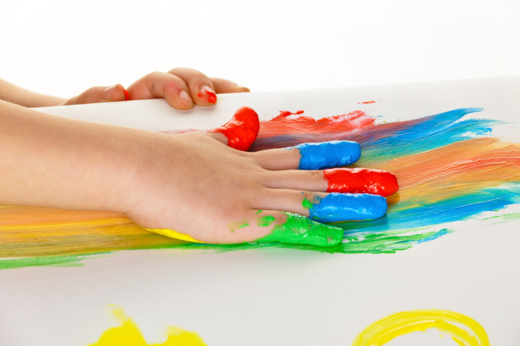 an autistic child painting with finger paints. funny and creative. Mom and little daughter sculpt new house of plasticine. Child development and education. Atlanta ABA therapy.