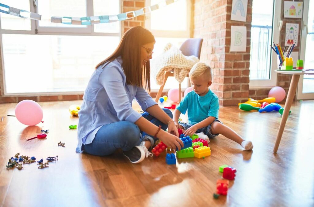 A compassionate ABA therapist at Kids Club ABA in Nebraska, helping a child develop social skills.