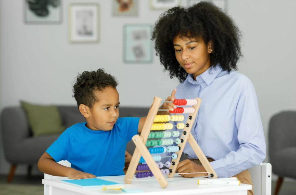 An ABA therapist at Kids Club ABA in New Jersey working closely with a child to develop key skills.