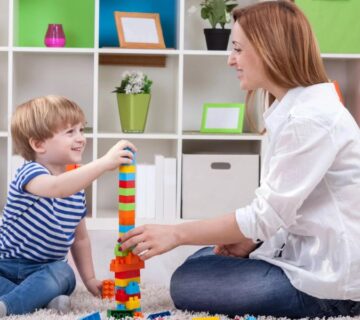 A therapist working one-on-one with a child during an ABA therapy session in an Atlanta clinic, focusing on communication and social skills development.