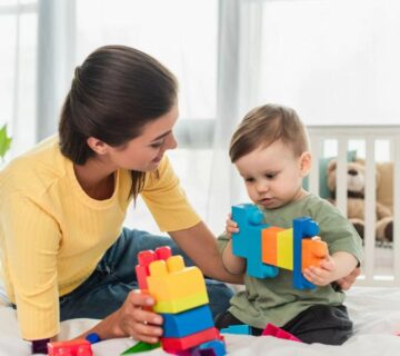 An ABA therapist working with a young child with autism at a therapy center in Atlanta, helping the child build communication and social skills.