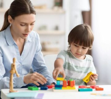 A therapist working with a child during an ABA therapy session in Atlanta, focusing on communication and social skills development.