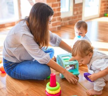 A parent sitting with a therapist and child during an ABA therapy session, actively participating and encouraging positive behaviors.