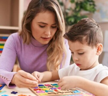 A therapist working one-on-one with a young child using ABA techniques in an Atlanta clinic setting.